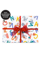 Gift box with colorful letter design and red ribbon on a white background, featuring '100% Melbourne Designed & Made' label.
