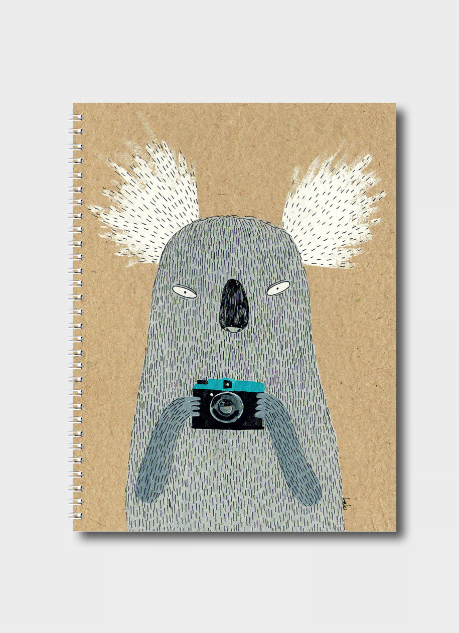 Luka Va notebook with a koala holding a camera on a natural kraft background.