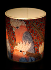 Decorative candle holder with cockatoo design on a dark background