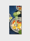 Yellow and orange nasturtiums flowers in a blue and white bowl on a navy background.