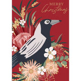 A red card with a black and white bird sitting amongst native flowers and the words Merry Christmas.