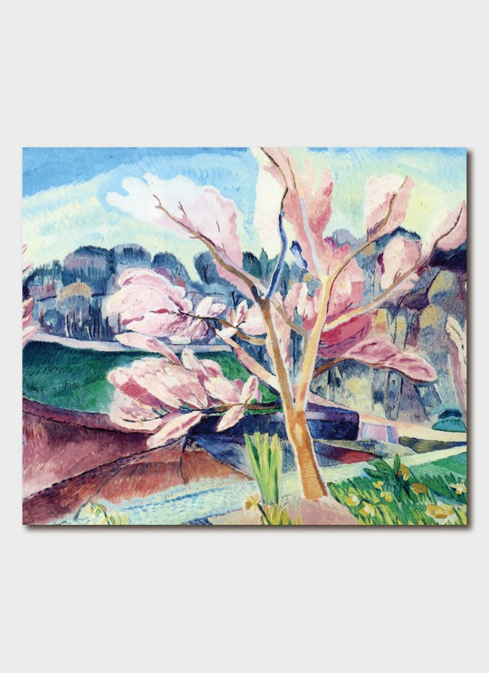 A flowering peach tree in pinks with a hill behind it.