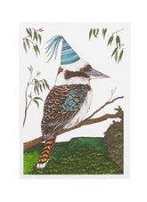 Kookaburra bird wearing a party hat on a branch with leaves in the background