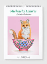 Calendar cover with a fox in a decorative bowl on a pink background, featuring the brand 'Michaela Laurie'.