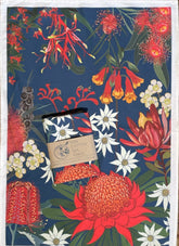 Floral patterned towel with a small towel and packaging on a blue background