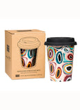 Colorful insulated mug with patterned design next to its packaging on a white background