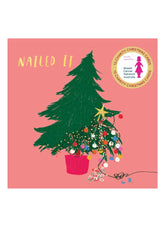 Christmas card with a decorated tree on a pink background, featuring the text 'Nailed It' and a logo.