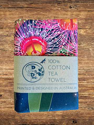 100% cotton tea towel with colorful design on a wooden surface