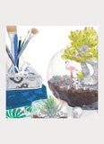 Terrarium, books and paintbrushes in a jar.