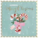 A square Christmas greeting card design with a scalloped gold border on a pale blue background. The card reads 'Have a very Merry Christmas' in gold script, with an illustration of two red-and-white striped candy canes, green holly leaves, berries, and a pink striped bow.