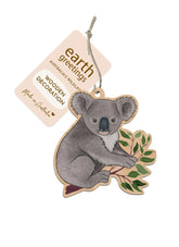 Wooden koala decoration with a tag labeled 'earth greetings' on a white background