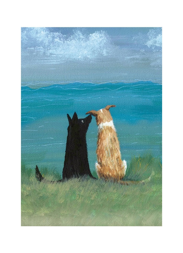 Two dogs, one black and one brown, sitting on a grassy field looking at the ocean.
