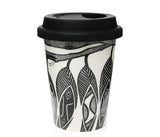 A reusable travel tumbler with a black lid, featuring a black and white graphic pattern of stylized faces and abstract line art, shown on a plain white background.