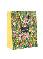 A yellow paper gift bag with a black cat in a field of flowers by Niaski
