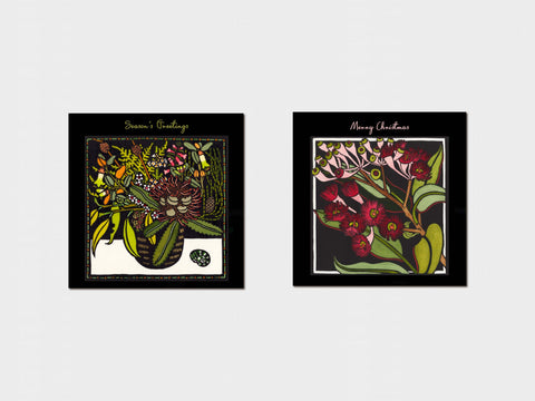 Two framed botanical artworks with 'Season's Greetings' and 'Happy Christmas' text on a white background.