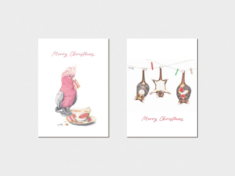 Two Christmas-themed cards with a pink cockatoo and hanging decorations on a white background.