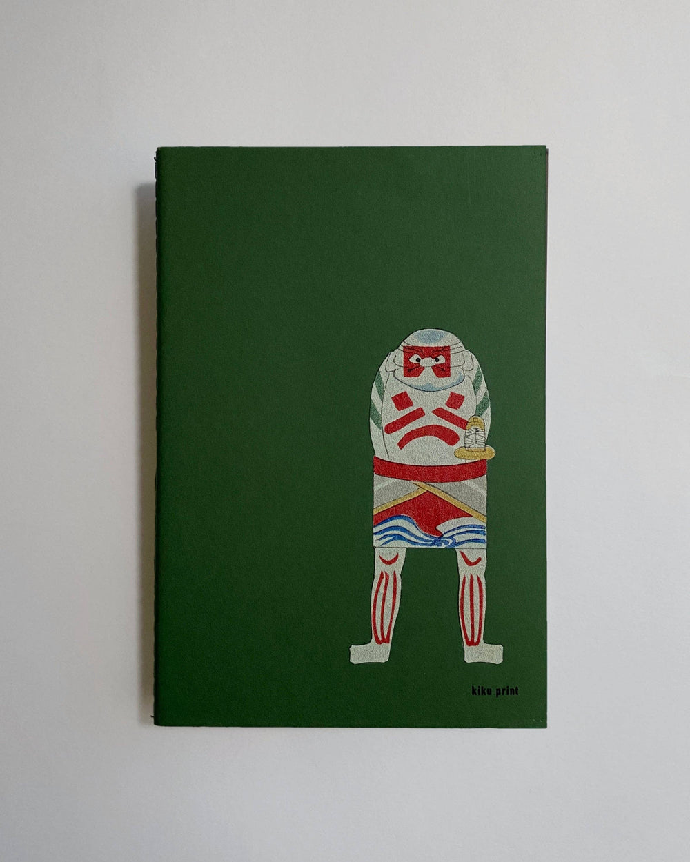 Green notebook with a graphic design of a character holding a British flag on a white background