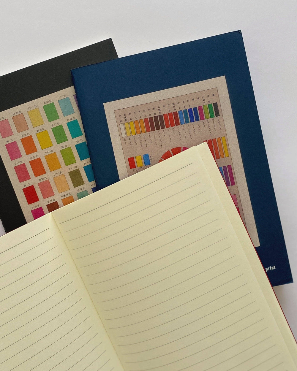 Notebook with colorful pages and a color swatch on a white background