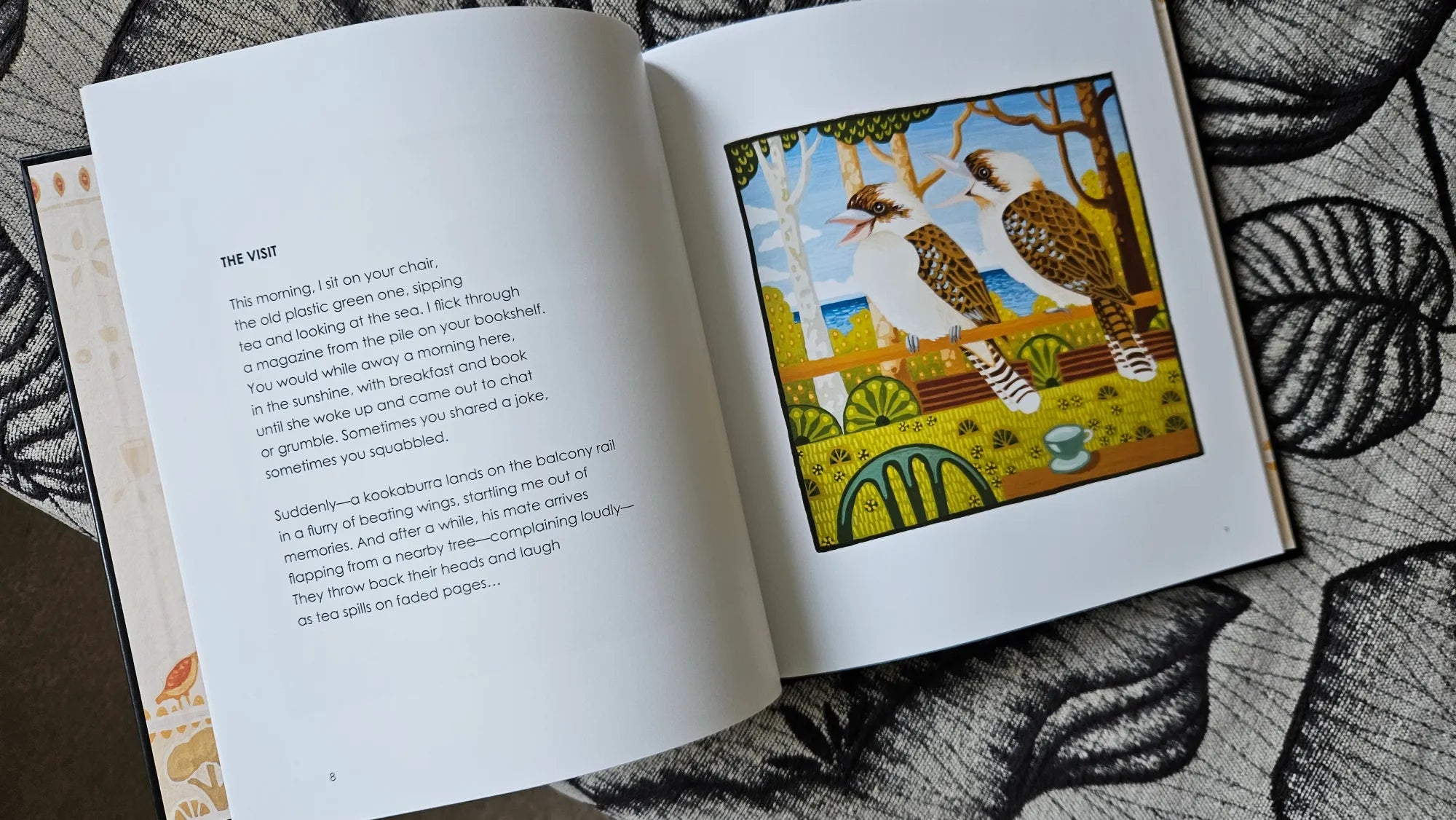 Open book with a colorful illustration of two birds on a leafy background