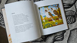 Open book with a colorful illustration of two birds on a leafy background