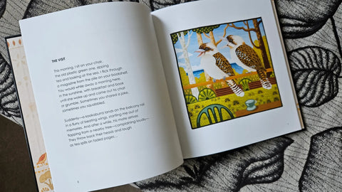 Open book with a colorful illustration of two birds on a leafy background