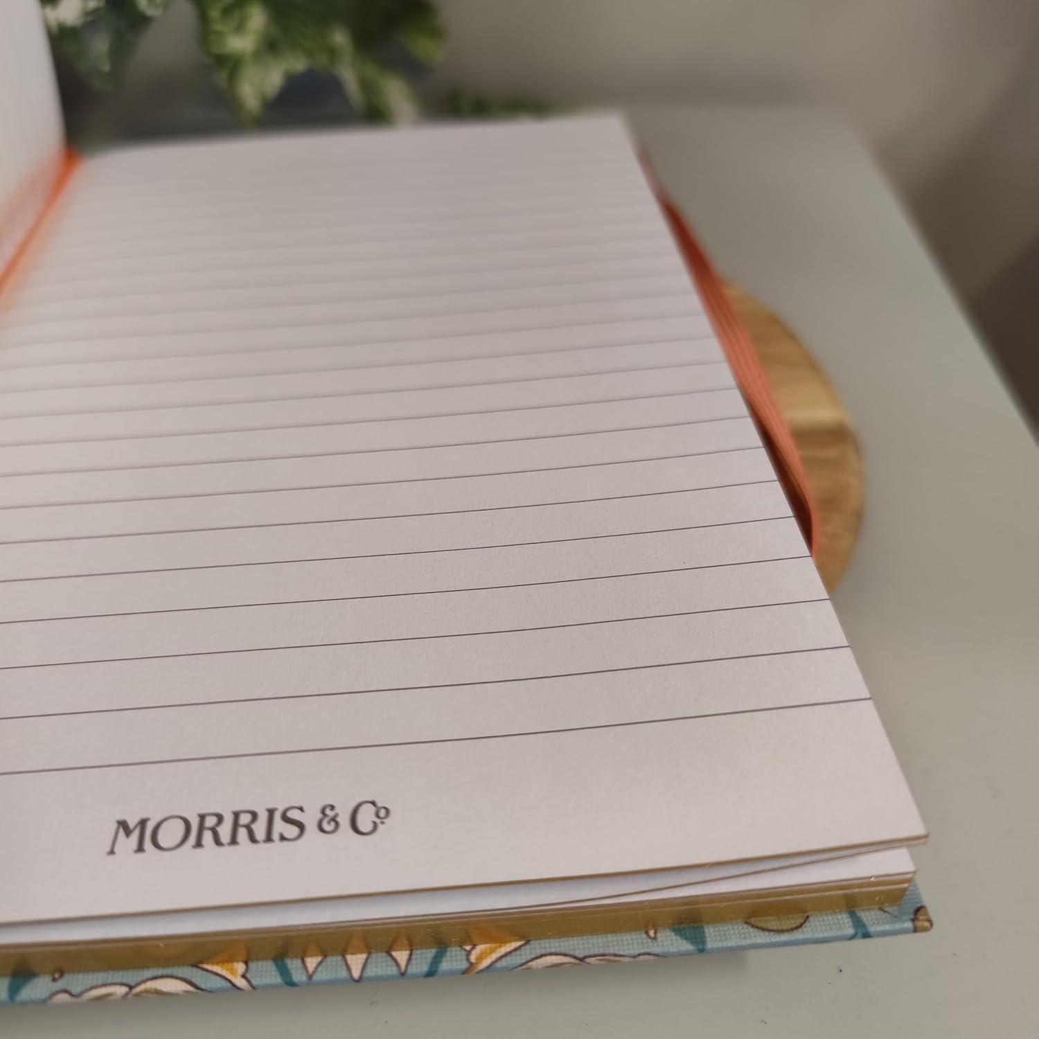 Notebook with lined pages and 'Morris & Co' branding on a blurred background