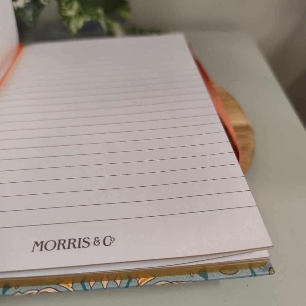 Notebook with lined pages and 'Morris & Co' branding on a blurred background
