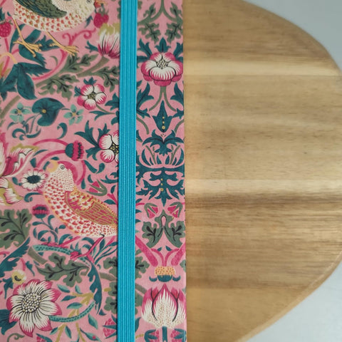 Decorative ribbon with floral and bird pattern on a wooden surface