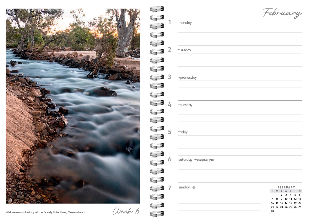 Calendar with a scenic view of a river and trees on one side and a grid layout on the other.