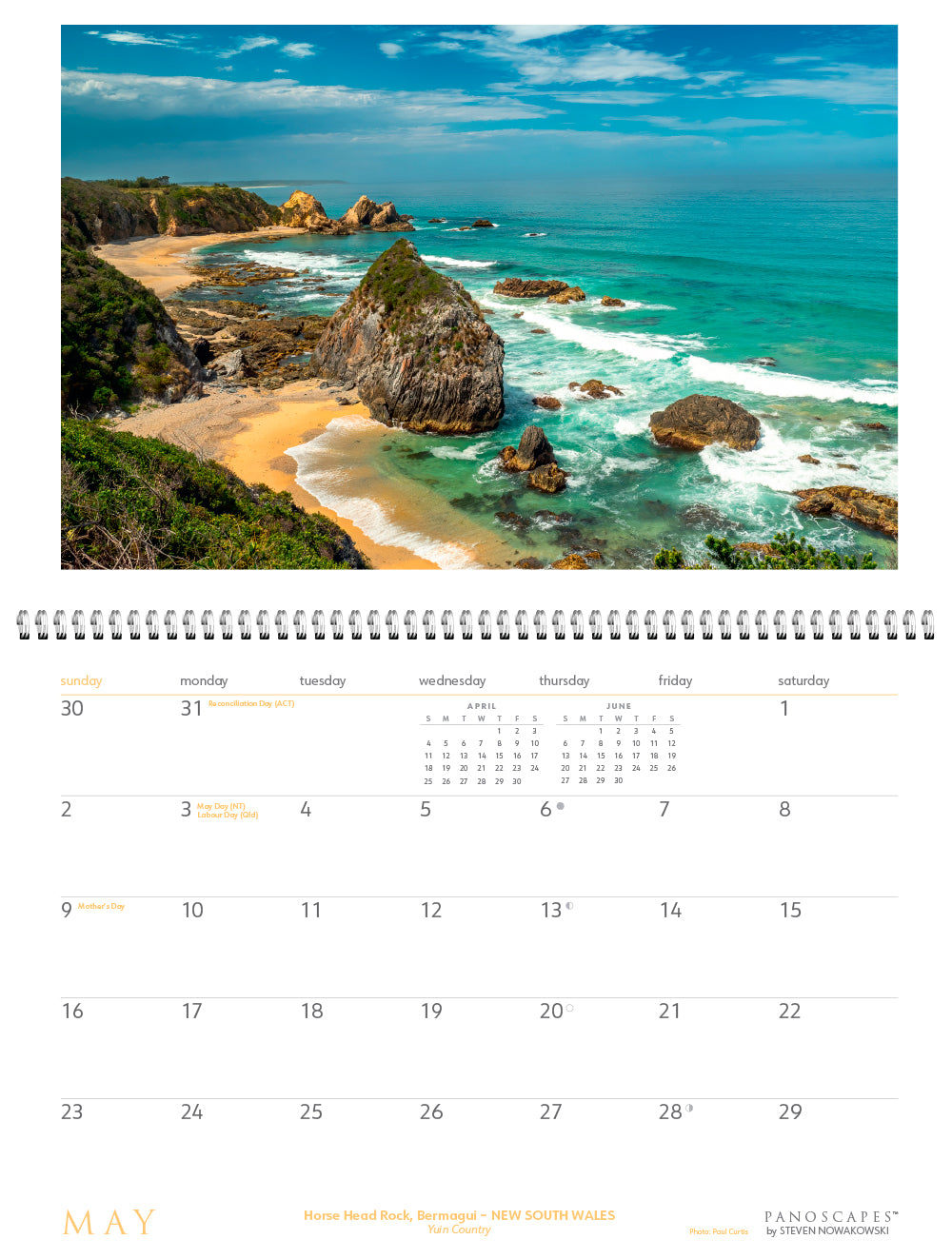 May page of calendar with an image of a coastline with surf and big rocks.