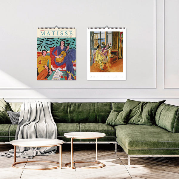 Living room with green sofa, coffee table, and Matisse art prints on the wall.