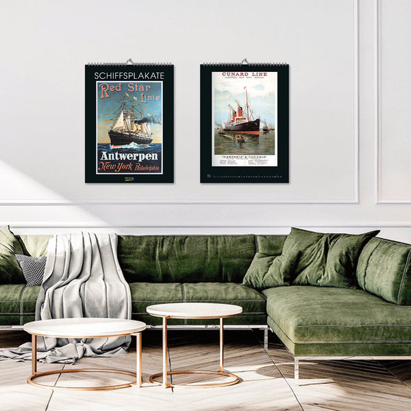 A room with green sofas with calendars on the wall.