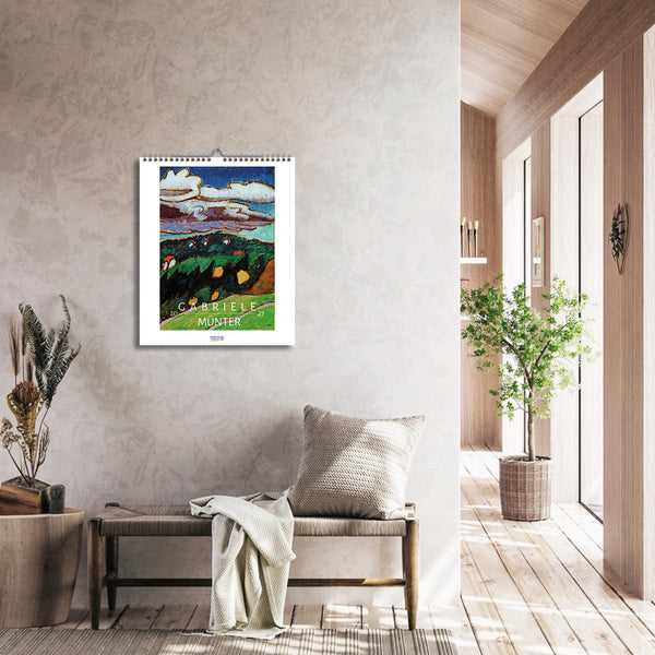 Calendar with artwork on a wall in a modern interior setting with a bench and plants.