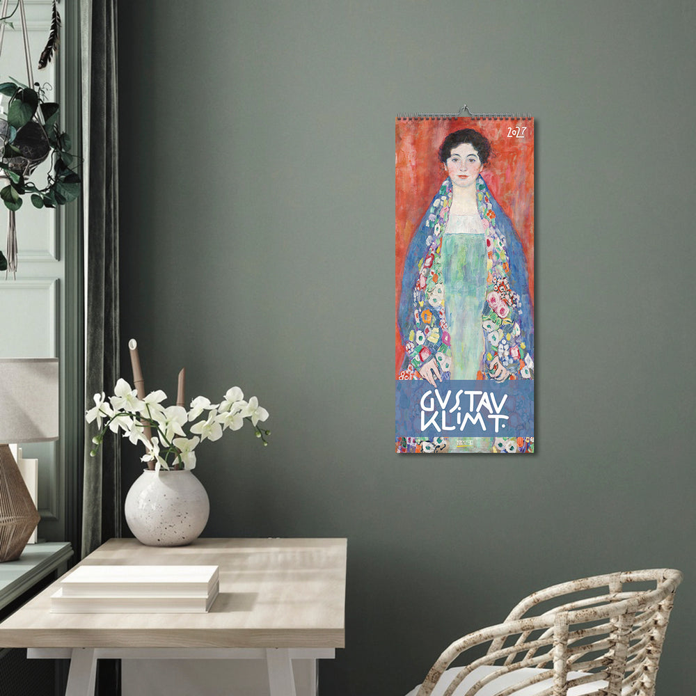 Poster of Gustav Klimt's artwork on a gray wall above a table with a vase and books.