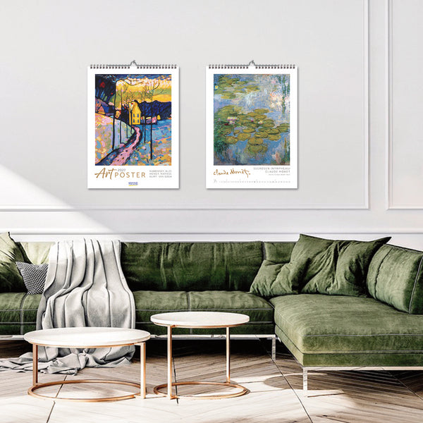 Two Art Foster calendars on a wall above a green sofa in a living room.