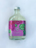 A bottle of Gernanium bath bubbles with a purple label in bath suds.