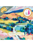 A Christmas greeting card featuring an expressive, colorful landscape painting with blue, green, yellow, pink, and orange brushstrokes. The card includes a gray banner in the top left reading 'AUSTRALIAN artist' and a circular gold seal in the top right that says '10 Charity Christmas Cards 10 Charity Christmas Cards Breast Cancer Network Australia' with a pink silhouette of a woman.