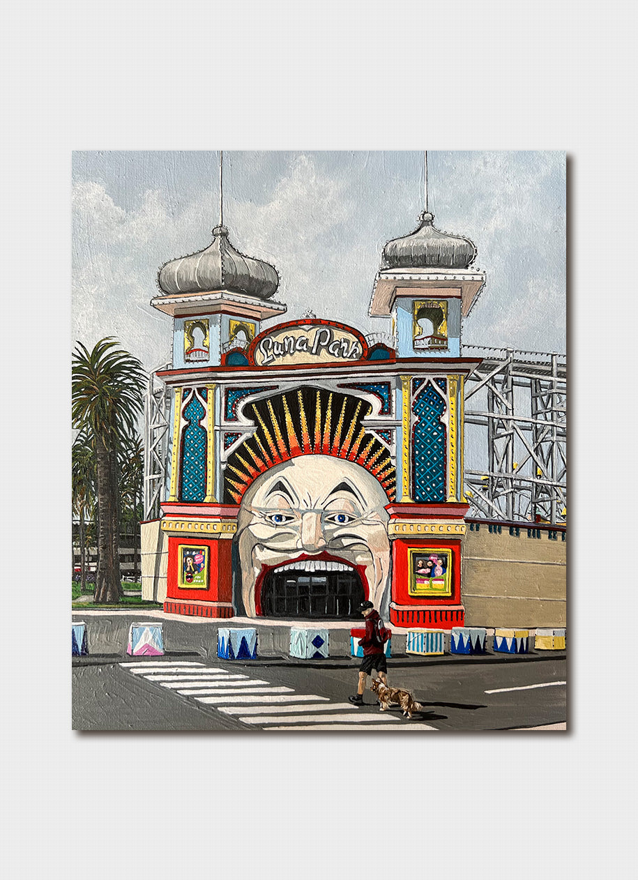 A funfair entrance with an open face and roller coasters.