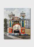 A funfair entrance with an open face and roller coasters.