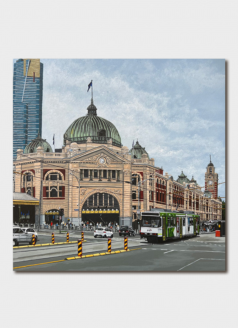 An old building on a major city corner with trams in front.
