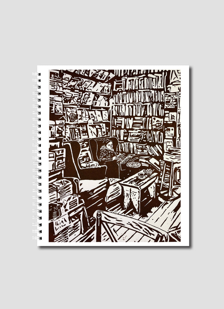 Cover of Literary Therapy By Mary Ann Hudson Small Notebook. Shows a lino cut of person in comfy chair, reading and surrounded by books.