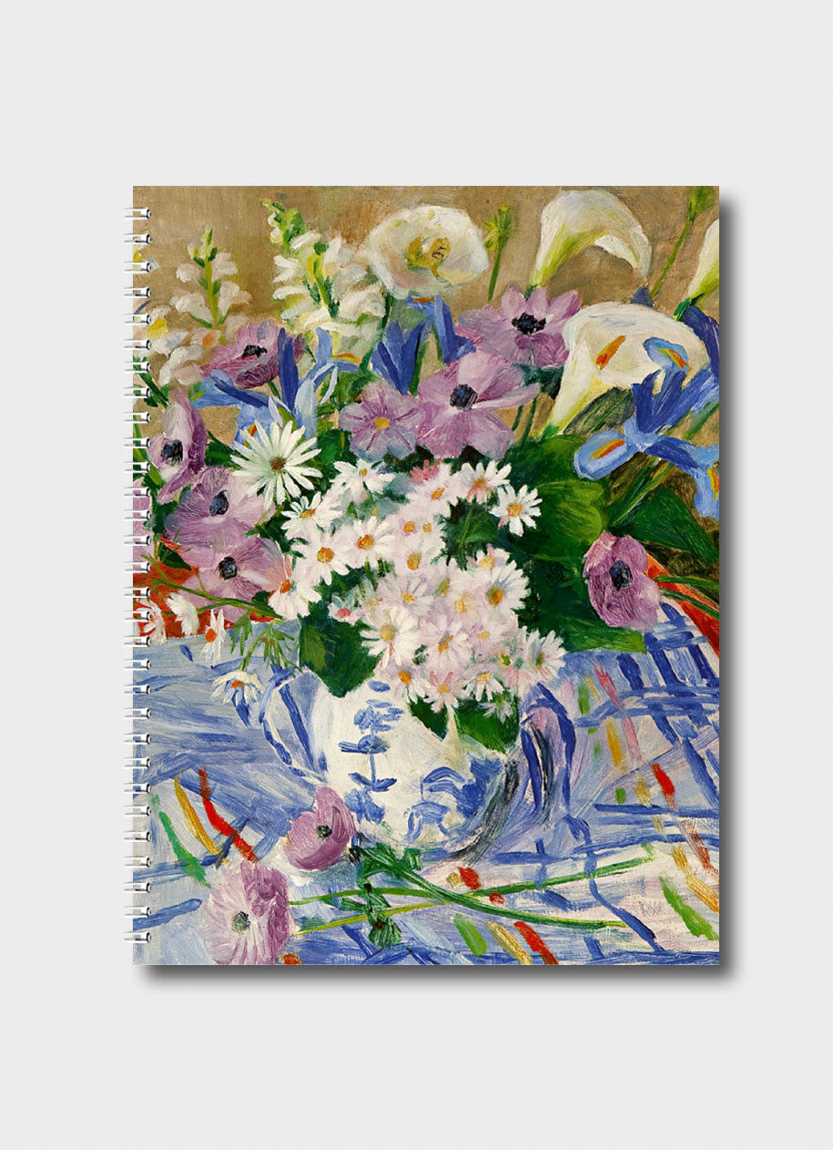 A vase full of colourful flowers on a striped colourful tablecloth.
