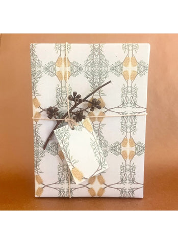 Gift wrapped in decorative paper with a branch on a brown surface