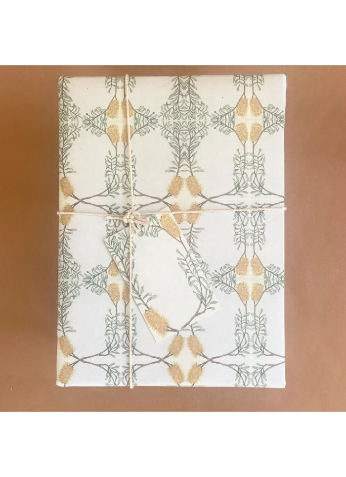 White towel with gold and green leaf pattern on a brown background