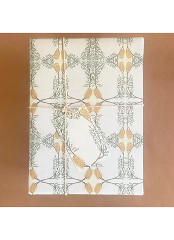 White towel with gold and green leaf pattern on a brown background