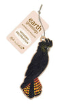 Wooden parrot decoration with 'earth greetings' tag on a white background