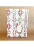 Notebook with geometric pink and gray pattern on a brown background