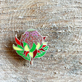 Colorful flower-shaped pin on a wooden surface