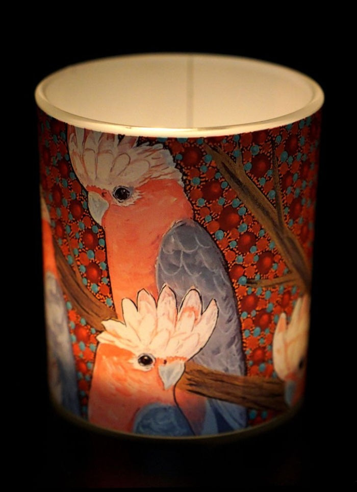 Decorative candle holder with cockatoo design on a dark background