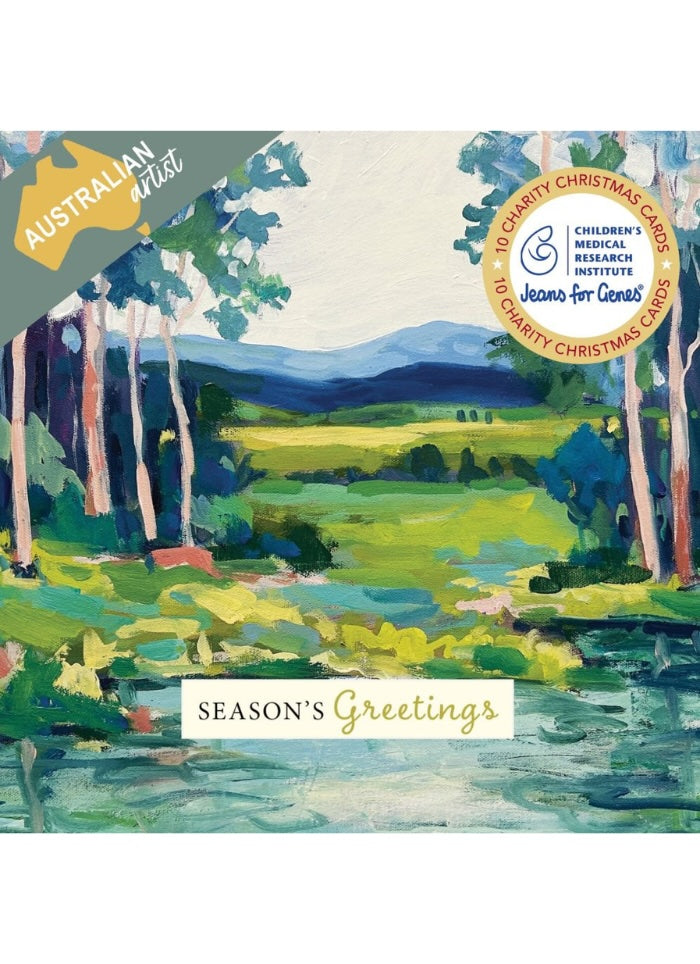 A Christmas greeting card featuring a watercolor landscape painting of a green valley with trees, mountains, and a river. The card includes 'AUSTRALIA artist' branding in the top left, a 'Season's Greetings' banner at the bottom, and a circular '10 Charity Christmas Cards' badge for Children's Medical Institute and Jeanne Guelag.